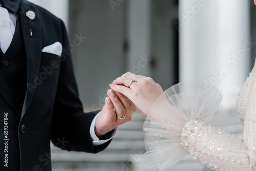 Muslim couple holding hands together with wedding rings, Muslim wedding, Wedding Poster, invitation card, copy space . photo