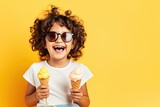 A cute and happy little girl enjoying a delicious ice cream cone on a warm summer day.