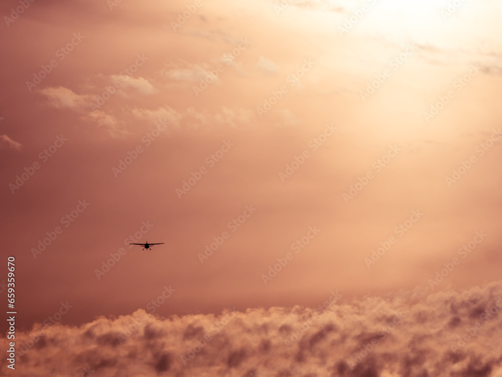Man sieht ein kleines Flugzeug von hinten wie es in den ruhigen Abendhimmel aufsteigt und in die Ferne fliegt. Man sieht ein kleines Flugzeug von hinten wie es in den ruhigen Abendhimmel aufsteigt und in die Ferne fliegt.
