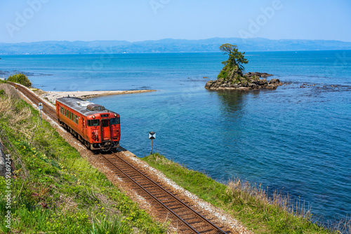雨晴海岸の景勝地を走る氷見線の列車