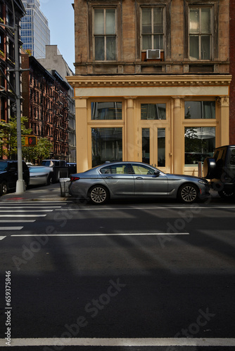 cars on pedestrian crossing near building with glass showcases on avenue in new york  city vibes