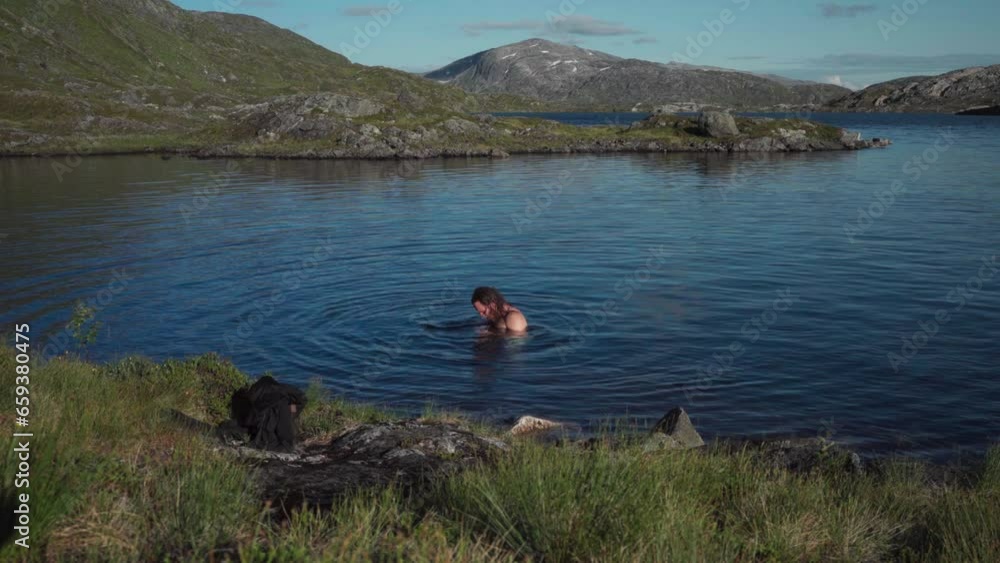 A Person Is Bathing In Botnvatnet Lake In Nordland, Norway. Static Shot