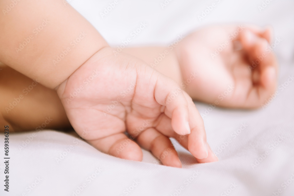 Hands of the woman and a child's hand on the white bed Hands of the woman and a child's hand on the white bed