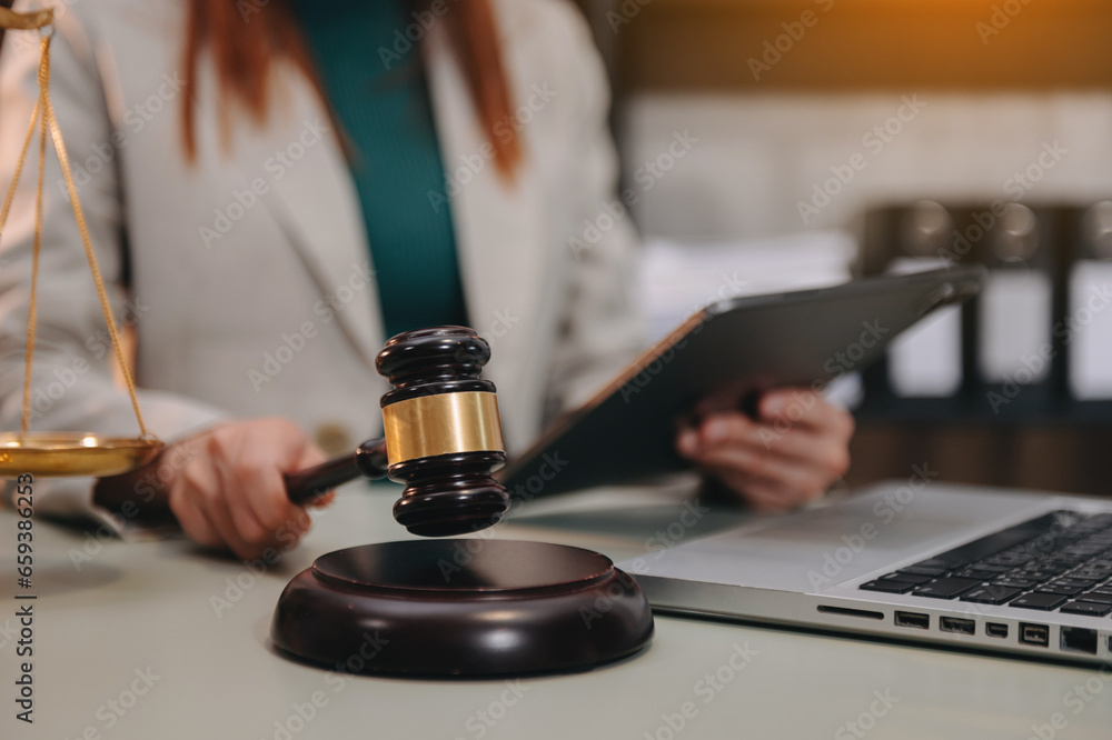 justice and law concept. asian woman lawyer working and judge in a courtroom the gavel, working with tablet and laptop and digital tablet computer