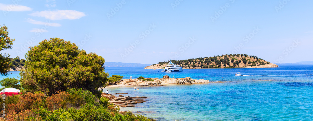 Impressive summer seascape of turquoise sea water and yacht at coast.