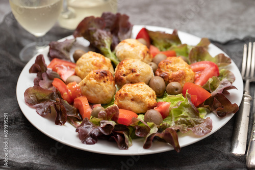 Chicken meatballs on lettuce with tomato and olives