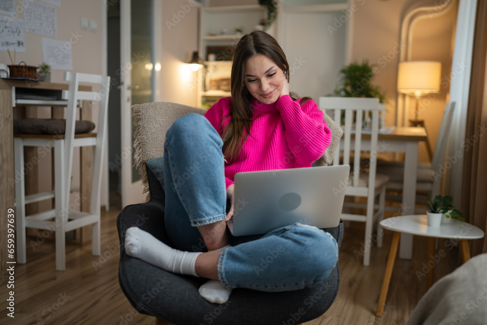 Obraz premium One young woman use laptop computer at home while sit comfortable
