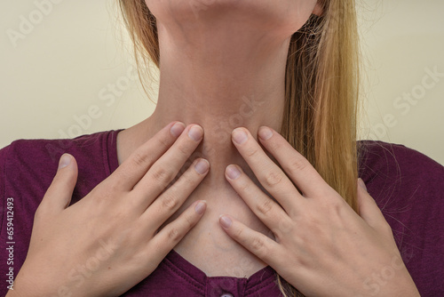 Ból szyi w okolicach krtani, przełyku, kobieta trzyma się za szyję 