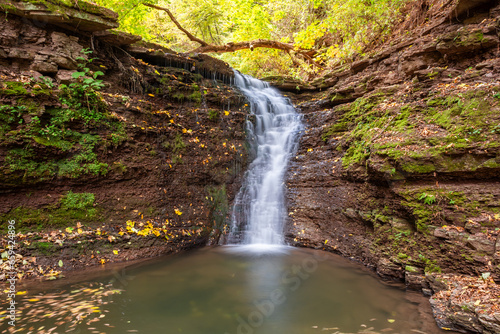 Beautiful waterfall in a mountain stream in the forest. One of the waterfalls of the cascade of Rusiliv waterfalls. Rusyliv  Ternopil Region  Ukraine