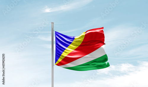 Seychelles national flag waving in beautiful sky. The symbol of the state on wavy silk fabric.
