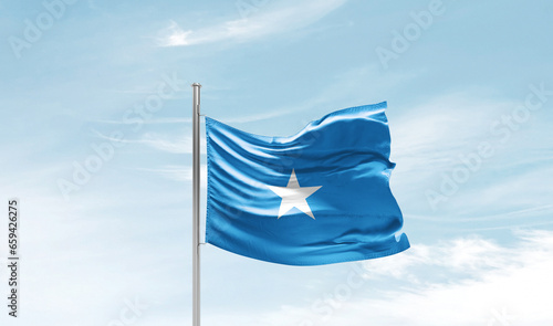 Somalia national flag waving in beautiful sky. The symbol of the state on wavy silk fabric.