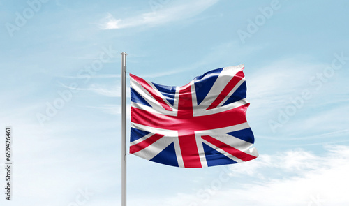 United Kingdom flag waving in beautiful sky. The symbol of the state on wavy silk fabric.