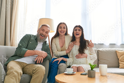 joyful father visiting his pregnant lesbian daughter, smiling sincerely at camera, ivf concept
