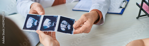 doctor showing lgbt couple their ultrasound of baby, in vitro fertilization concept, banner