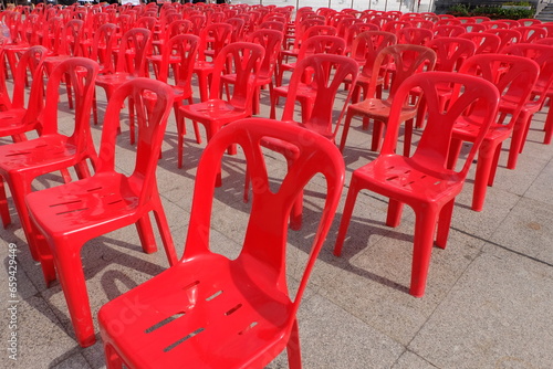 Red chairs for attendees of meetings, seminars, and recreational activities. Arrange them in rows in an outdoor location.