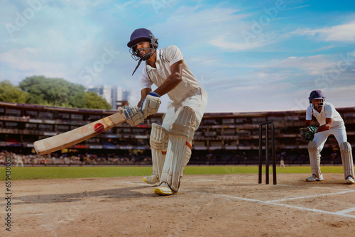 Cricketer batsman hitting a Reverse Sweep during a match on the pitch