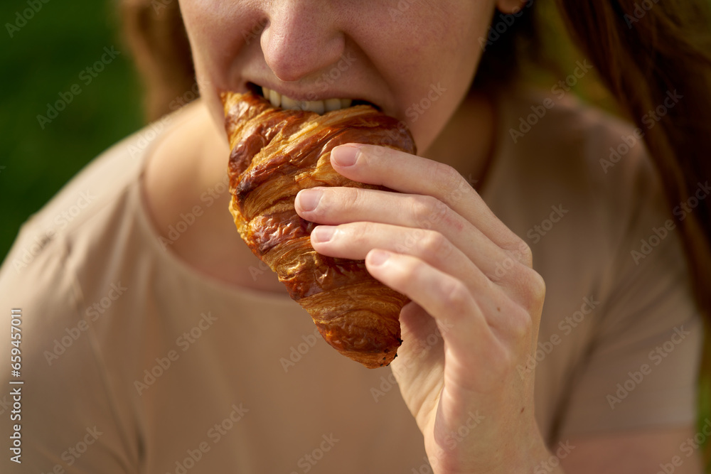 Female hands hold a ruddy and freshly baked croissant, clear and sunny day. Female hands hold a ruddy and freshly baked croissant, clear and sunny day.
