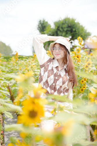 Portrait young woman in a field of sunflowers, Happiness asian woman in a field of sunflowers, Portrait asian woman in a field of sunflowers 