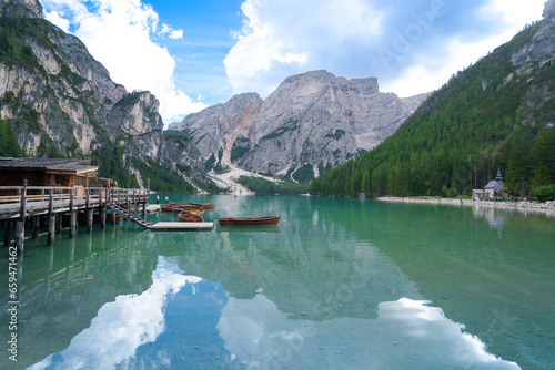 Landscape of Lago di Braies in dolomite mountains. wooden boat hut on Braies Lake with Seekofel mount on background, Italian Alps, Nature park Fanes-Sennes-Prags, Dolomite, Italy, Europe.