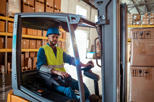 Portrait of young forklift operator working in a warehouse