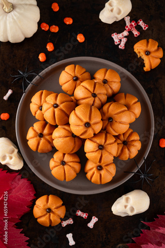 Halloween spicy mini cheesecakes with pumpkin puree in the form of small pumpkins. Halloween or Thanksgiving dessert.