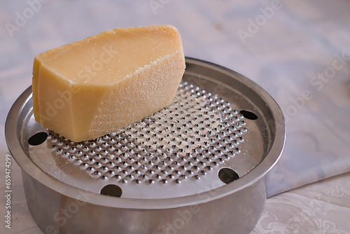 Parmesan cheese piece on a grater, a typical cheese in Mediterranean cuisine