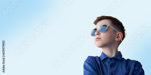 Boy (8-9 years old) in sunglasses looking to the side, space for text