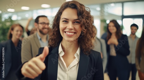 Smiling businesswoman showing thumbs up with colleagues.