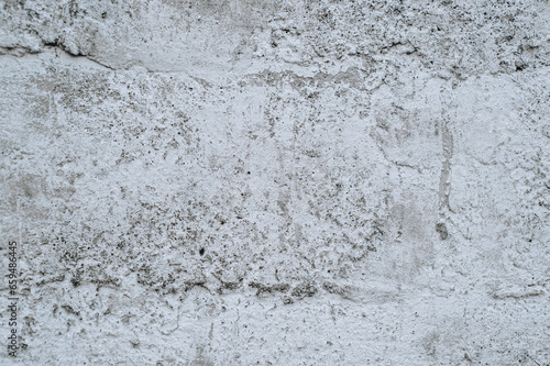 Gray stained concrete wall, dirty cracked uneven cement surface with paint close-up. Photography, abstraction, background.
