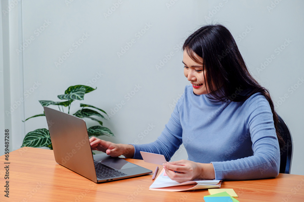 Woman holding plastic credit card and using laptop. Online shopping concept. Woman holding plastic credit card and using laptop. Online shopping concept.