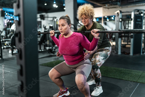  Two beautiful, overweight women push their limits during a workout, supporting each other every step. 