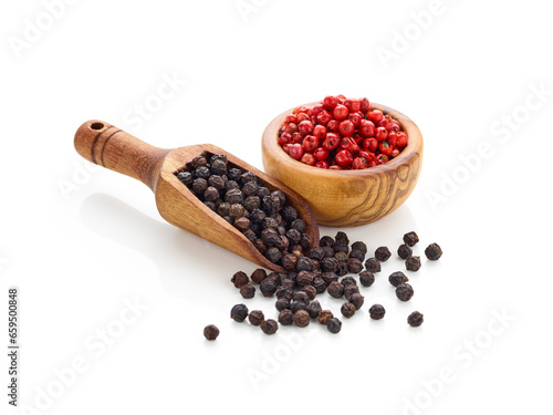 Black pepper in wooden spoon and peppercorn in wooden bowl isolated on white background