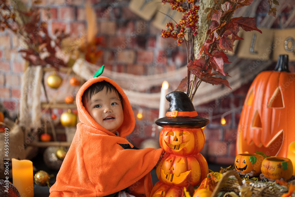 10月にハロウィンのフォトセットに囲まれて楽しそうな笑顔を見せる生後11か月の赤ちゃん
