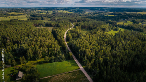 Tranquil Countryside Hilltop with Green Grassland and Beautiful Aerial View of Nature. Vast green farmland stretches to the horizon, serene and untouched.