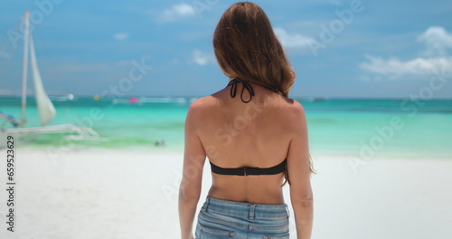 Woman in bikini walks white sand beach on tropical Boracay island, Philippines. Long hair Caucasian girl back view enjoys wild nature landscape, turquoise water and blue sky. Travel, tourism, holiday © Anastasia Pro