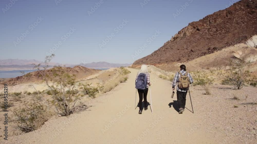 Two senior is hiking at rocks area during sunshine weather. Couple travelers research rock place in Nevada. Two senior is hiking at rocks area during sunshine weather. Couple travelers research rock place in Nevada.