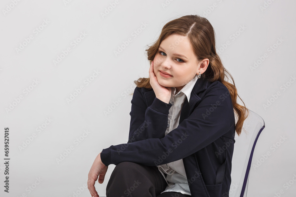 girl model in white shirt and black trousers sits relaxed in studio