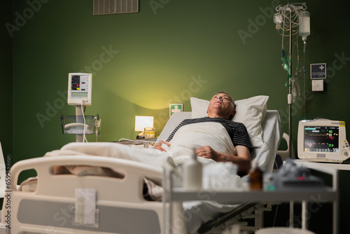 Elderly patient resting at the hospital, with tube and finger thing