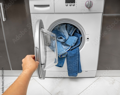 Washing machine overflowing with clothes. Wrong wash.