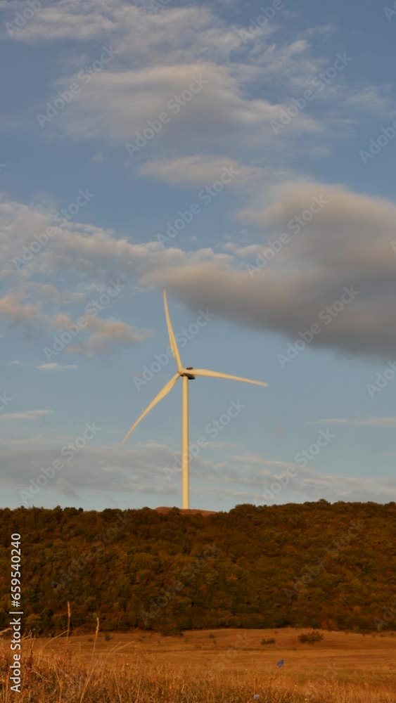 Vertical video of wind turbines at sunset in a field. The propeller blades rotate with the help of the wind and produce electricity without harming the environment. Future technologies. love ecology Vertical video of wind turbines at sunset in a field. The propeller blades rotate with the help of the wind and produce electricity without harming the environment. Future technologies. love ecology