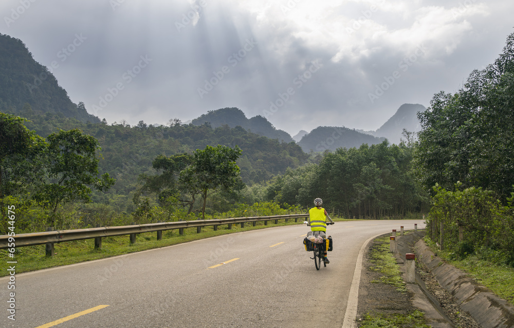 Female adventurer on a touring bike, nomadic woman travels on her bicycle loaded with bags Female adventurer on a touring bike, nomadic woman travels on her bicycle loaded with bags