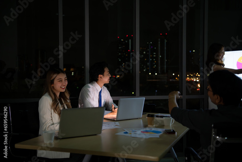 Group of broker international stock traders working actively at night in office, Everyone is striving for the team's success.