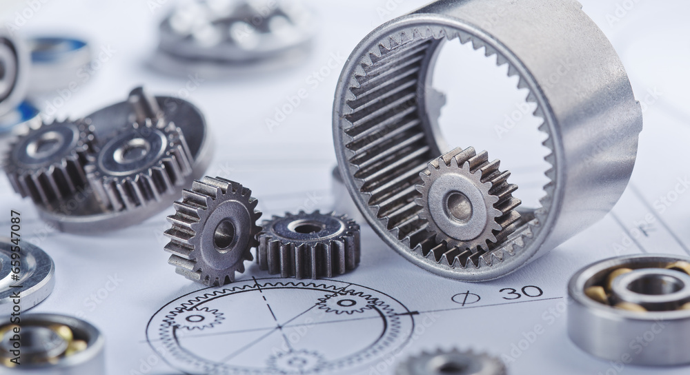 Close up metal gears and bearings. Background with drawings of the mechanism. Industrial mechanism. Close up metal gears and bearings. Background with drawings of the mechanism. Industrial mechanism.
