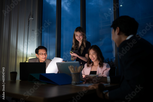 Group of business people working in office at night. Business concept.