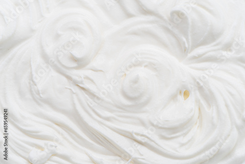 Creamy waves and swirls in yoghurt or cream surface. Top view.