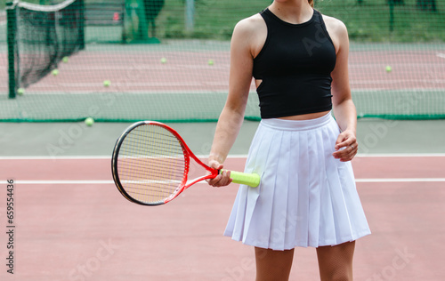 Girl in a white skirt with a racket on the tennis court. Sport © schankz
