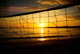 silhouette of a beach volleyball net against the setting sun and ocean