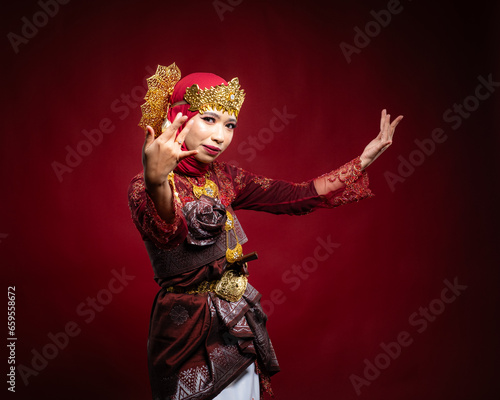 An Asian female traditional damcer wearing a traditional apparel and accessories dancing the traditional dance photo