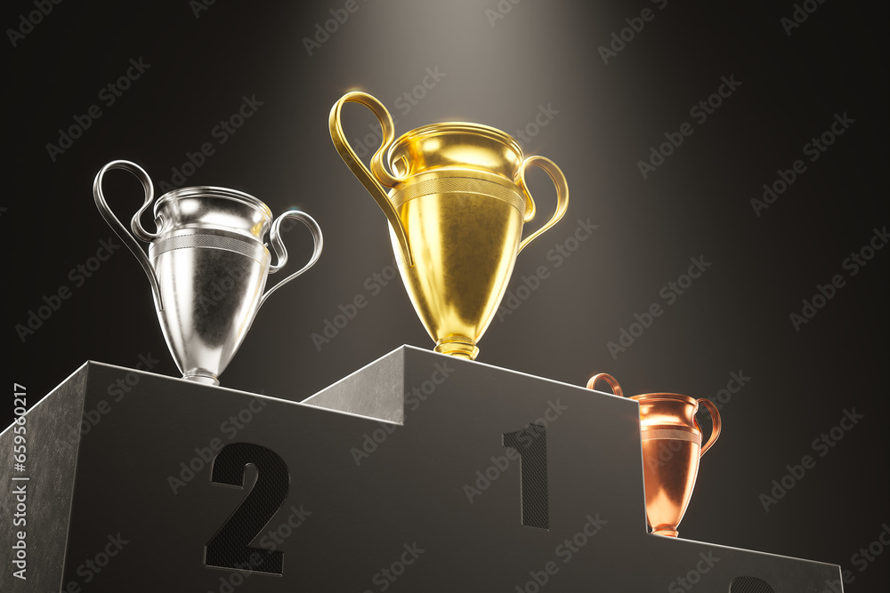 Golden, silver and bronze metallic trophy cups on a podium in the spotlight