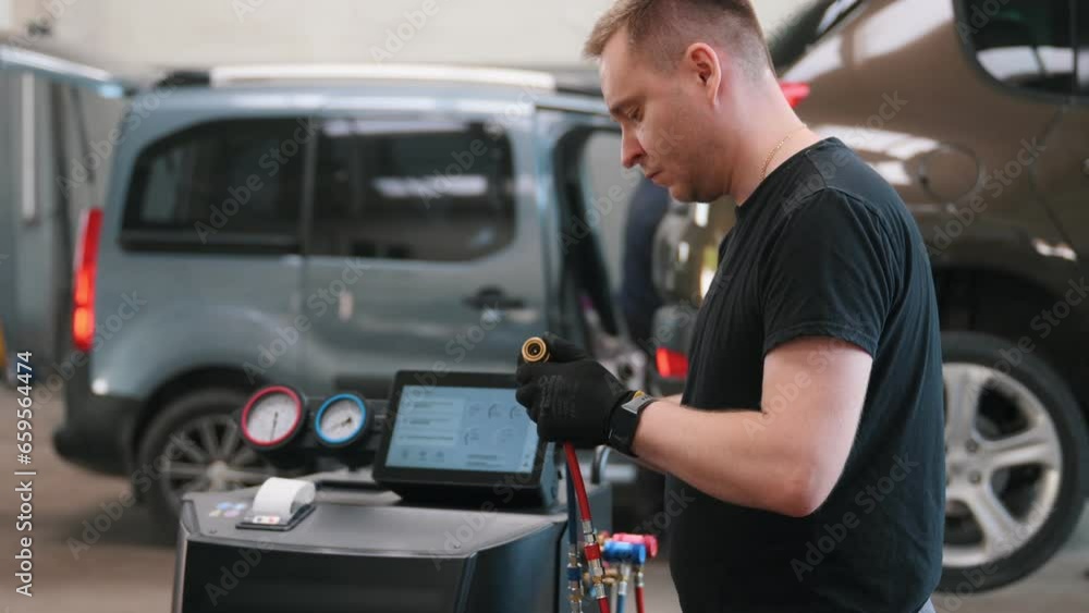Car mechanic with manometer to fill the gas in the car air conditioning compressor. Service of checking the car air conditioner. Refrigerant recharge system. Car mechanic with manometer to fill the gas in the car air conditioning compressor. Service of checking the car air conditioner. Refrigerant recharge system.